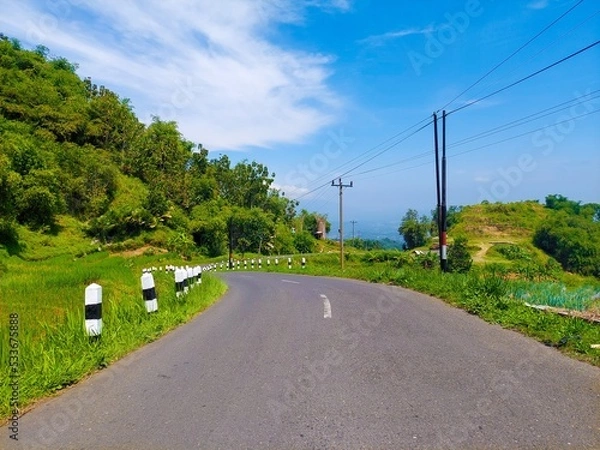 Obraz a highway under the hills against the background of a bright blue sky