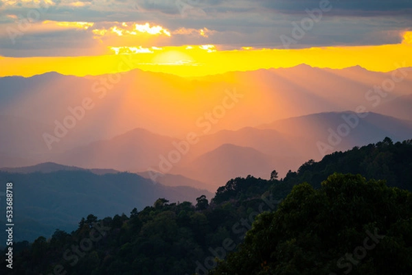 Obraz Dramatic sunset over mountain ranges with orange sunlight.