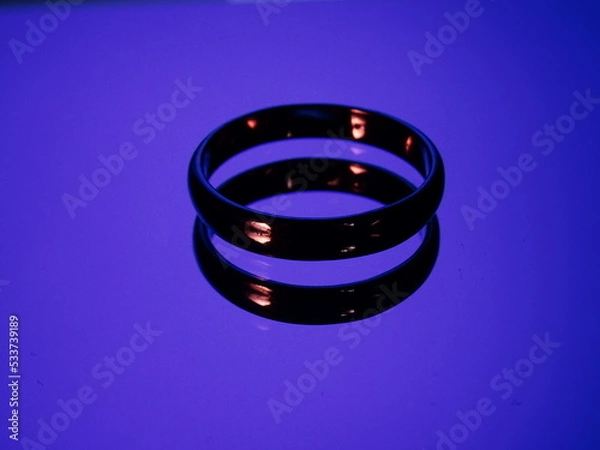 Obraz Rings with fire reflection on blue background