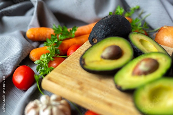 Obraz Vegetables for vegan salad. Avocado, Carrot, Tomatoes, Garlic, Onion, Parsley.