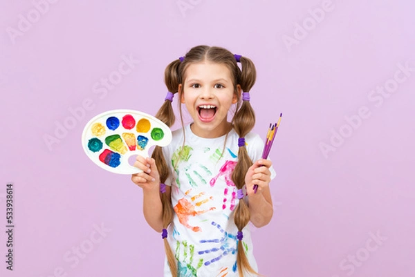Obraz Development of children's creativity and drawing with paints. A beautiful girl with paints, brushes and palette in her hands on a purple isolated background.