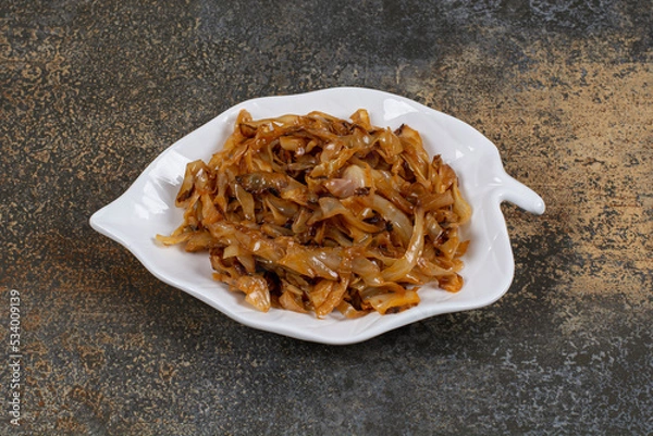 Obraz Fried caramelized onion pieces on leaf shaped plate
