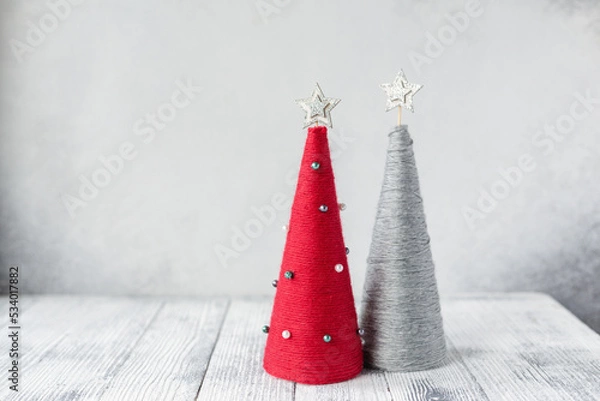 Fototapeta Christmas greeting card with yarn wrapped XMAS cone trees. Two handmade Christmas trees with copy space for your congratulations