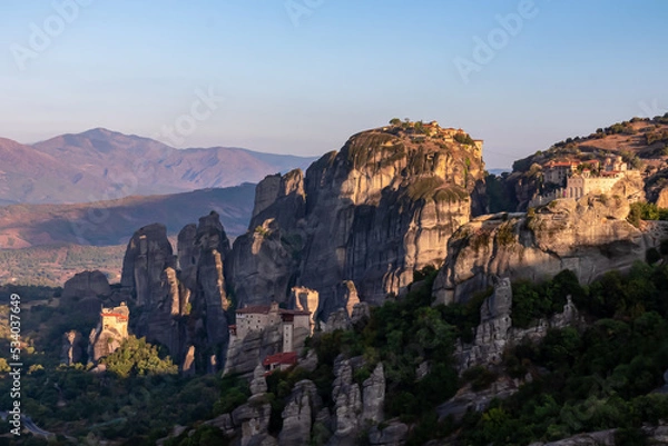 Fototapeta Early morning aerial panoramic view during sunrise of the monasteries of Meteora (Great Meteoron, Varlaam, Rousanou, Nicholas Anapafsas, Holy Trinity) in Kalambaka, Meteora, Thessaly, Greece, Europe