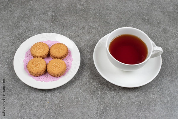 Obraz Delicious round biscuits and cup of tea on marble surface