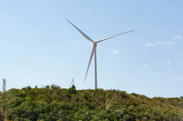 Fototapeta A wind generator standing on a hill generates electricity.
