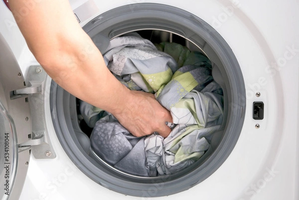 Obraz Woman's hand Pick up clothes Washing machine. Clean and Healthy Concepts.