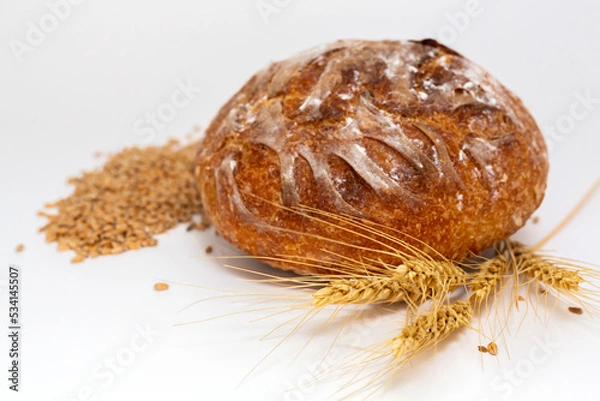Obraz Baked bread and wheat. White background.