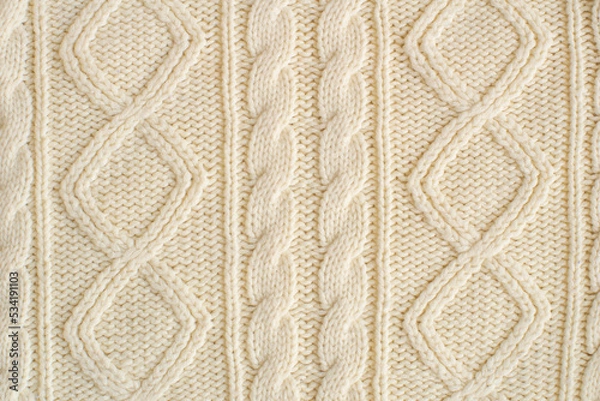 Fototapeta knitted milk sweater with a pattern of braids close-up. Knitted natural wool yarn texture. Texture