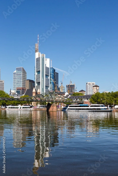 Fototapeta Frankfurt skyline with Main river and Eiserner Steg Bridge travel traveling portrait format in Germany