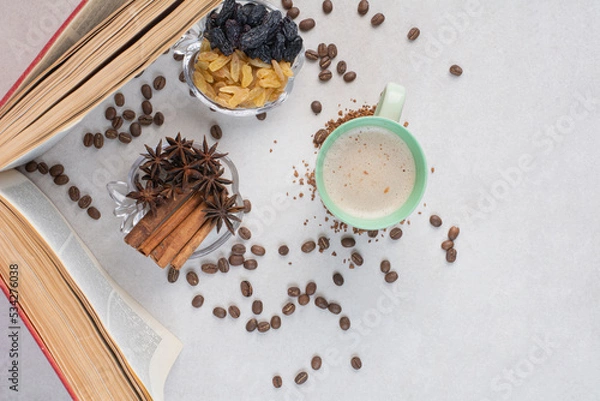 Fototapeta An opened book with cup and coffee beans on marble background