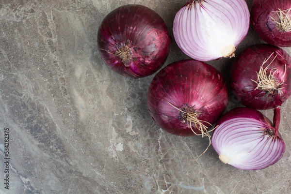 Obraz A lot of red onion bulbs on marble background