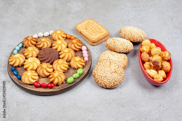 Fototapeta An assortment of cookies and biscuits with candies on marble background