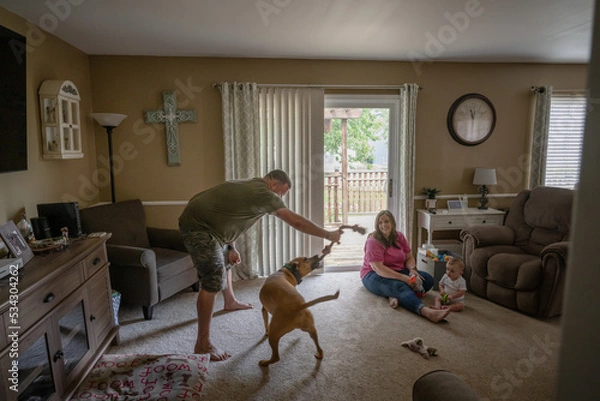 Fototapeta Marine veteran with service dog and family living life.
