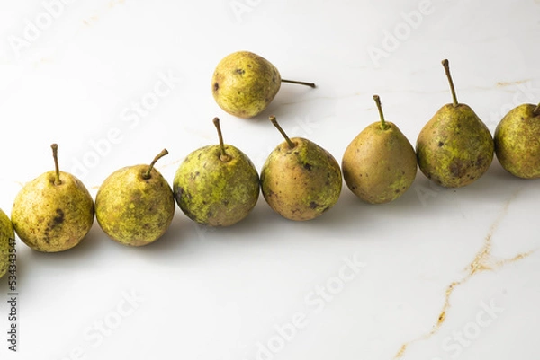 Fototapeta juicy green duchess pears harmoniously lie in the composition on a light white marble background