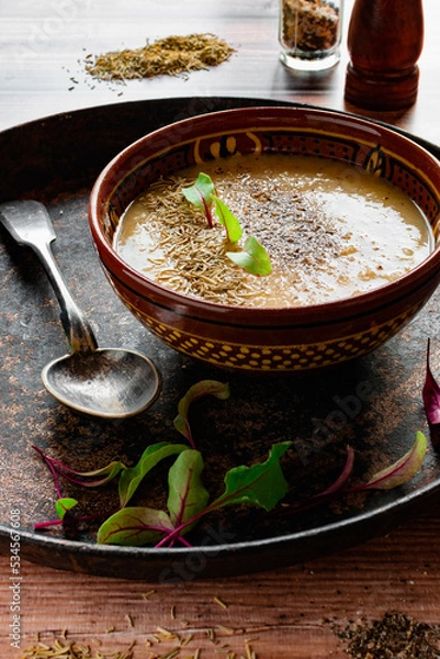 Fototapeta Pea soup puree with spices in a vintage dish and a plate with spices, rare cutlery, homemade food in the village