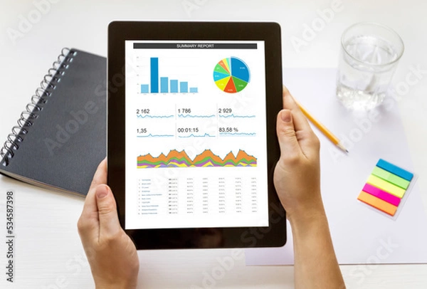 Fototapeta Top view of hand keep digital tablet with analytical data by summary report