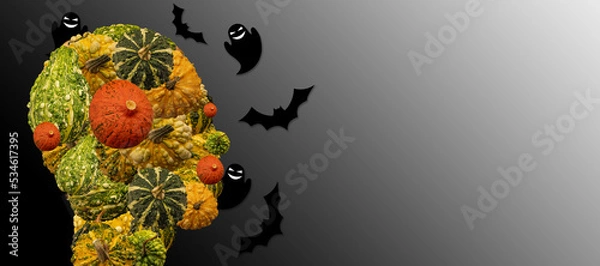 Fototapeta Head of a person made of decorative and halloween pumpkins with ghosts and bats around. Halloween symbols. Darkness surrounding.