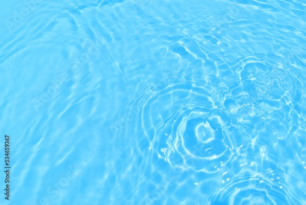 Fototapeta Defocus blurred transparent blue colored clear calm water surface texture with splash, bubble. Shining blue water ripple background. Surface of water in swimming pool. Blue bubble water shining.