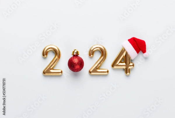 Obraz New year 2024 number, golden digits and santa hat over blue background.