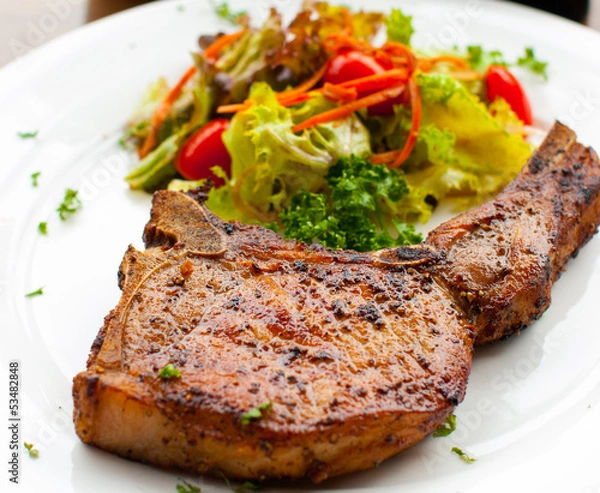 Obraz Pork chop with salad close up