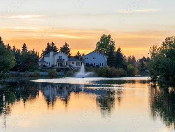 Fototapeta sunset over the lake with a fountain and vivid reflections
