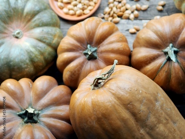 Fototapeta Autumn pumpkin background on a wooden ancient table. Pumpkin harvest with seeds. Photo from above.