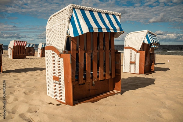 Obraz Wicker roofed beach chairs at the sand beach. Strandkorb at north seashore. 