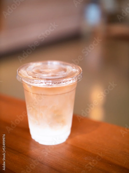 Fototapeta Soft focus iced-latte coffee on wooden table with blurred background
