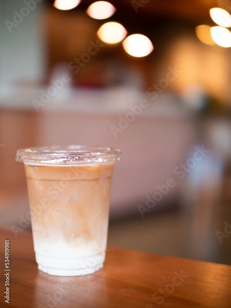 Fototapeta Soft focus iced-latte coffee on wooden table with blurred background