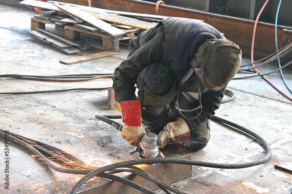 Obraz Worker is cutting metal by grinder