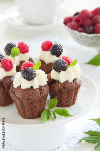 Fototapeta Chocolate muffins with raspberries and cream.