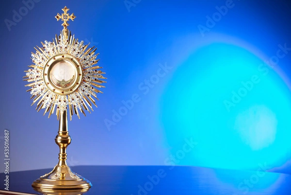Fototapeta Catholic religion concept. Catholic symbols composition. The Cross, monstrance,  Holy Bible and golden chalice on blue bokeh background. 