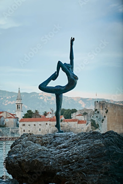 Obraz statue of a ballerina on top of the rock in old city of budva