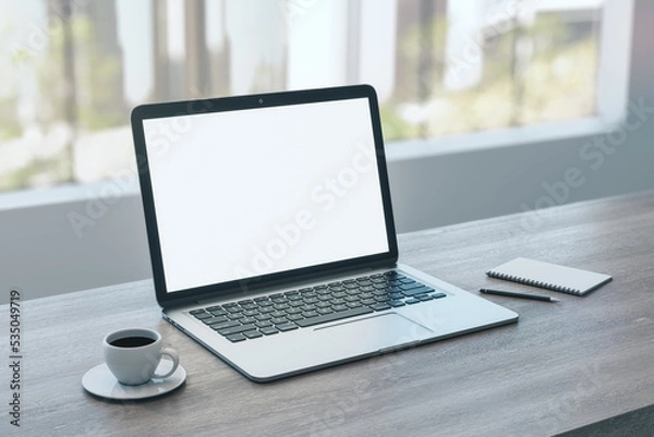 Fototapeta Close up of empty white laptop on wooden desktop with coffee cup, notepad, pen, mock up place on screen, blurry office interior with window and city view background. 3D Rendering.