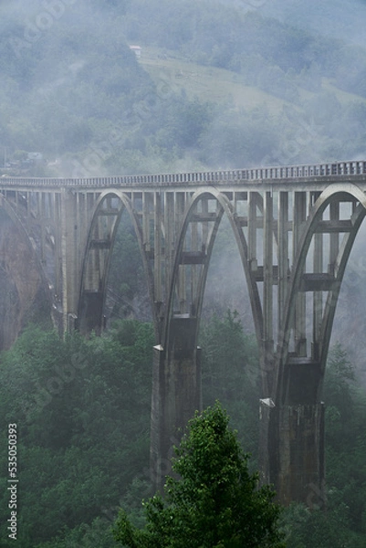 Obraz tall bridge over the river covered with fog