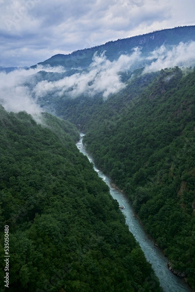Obraz clouds over the river in canyon surrounded by forest