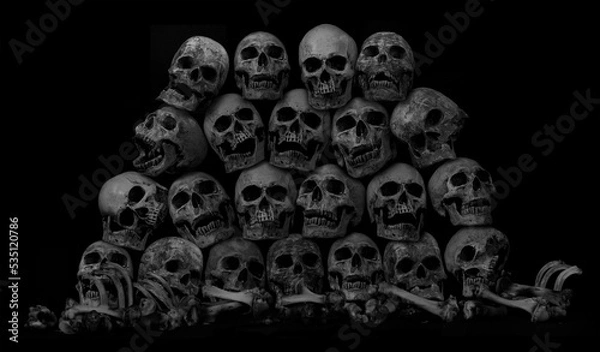 Fototapeta Awesome pile of skull human and bone on black cloth background, concept of scary crime scene of horror or thriller movies,Halloween theme, Still Life style, selective focus,