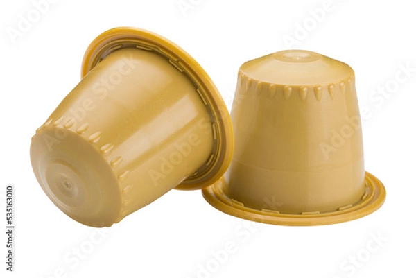 Obraz Two yellow capsules with ground coffee, for a capsule coffee machine, on a white background, one capsule is overturned, isolate
