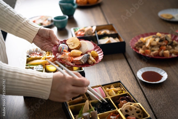 Fototapeta おせち料理を取り分ける女性の手元
