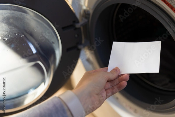 Obraz Woman putting a laudry sheet in the washing machine