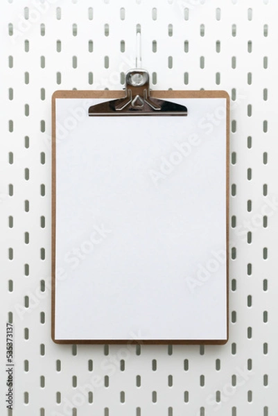 Fototapeta Clipboard with blank paper and copyspace for text on peg board