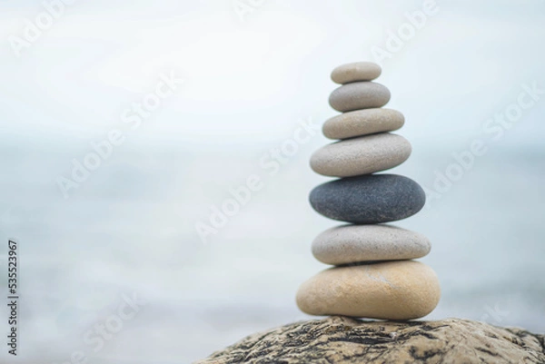 Fototapeta Pebble tower balance harmony stones arrangement on sea beach coastline peaceful formation pyramid