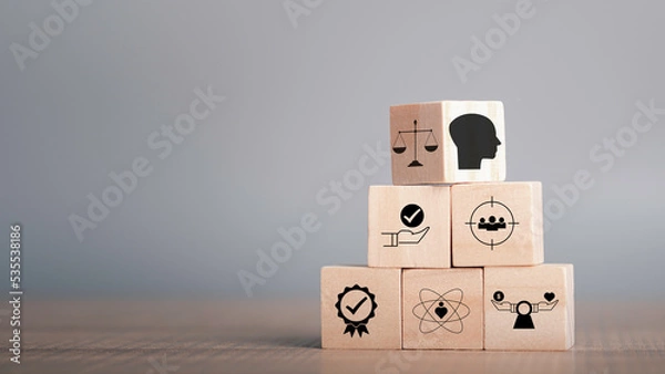 Fototapeta Ethics inside human mind, Business ethics concept. Ethics inside a head symbols in wooden cubes stacked on gray background with copy space.