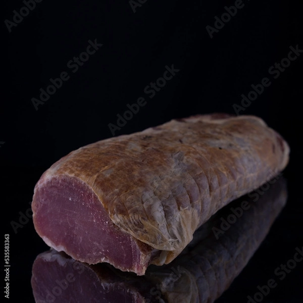 Fototapeta piece of jerky on a black background with reflection