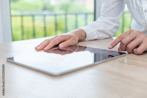 Obraz Digital tablet computer with a blank screen in the hands on wooden table