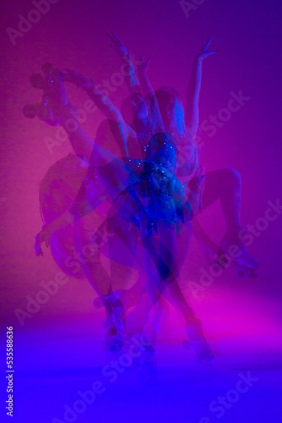 Obraz Dancing young mixed race girl enjoying moving in colorful neon studio light. Long exposure. woman dancing on roller skates, figure skating