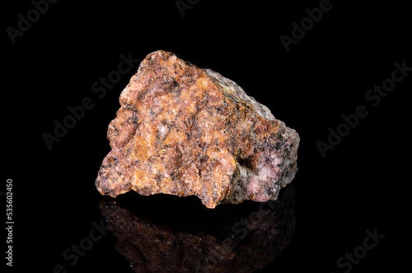 Fototapeta A fragment of the mineral granite with a granular structure. Reddish stone with white and black patches