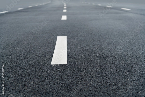 Fototapeta Asphalt road with white dashed lines
