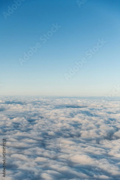 Fototapeta Looking at the cloudscape through airplane window